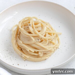 A tantalizing image of vegan creamy pasta, Cacio e Pepe style, with a sprinkle of pepper.