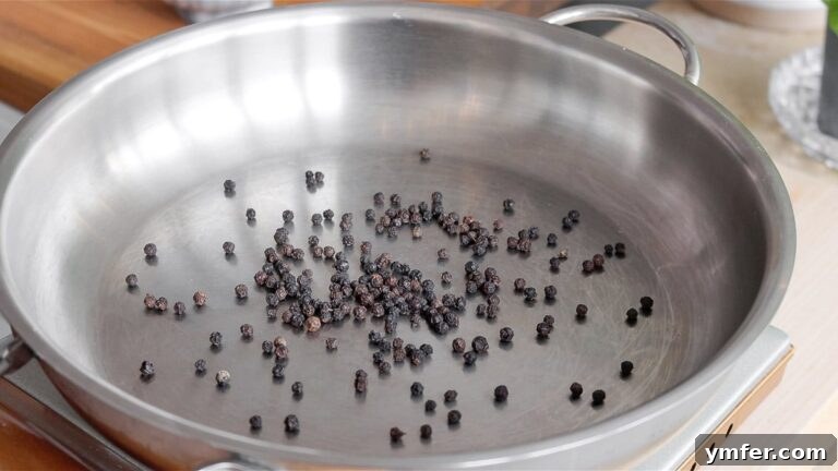 Creamy Vegan Pepper Pasta 17 Toasting whole black peppercorns in a pan to intensify their flavor.