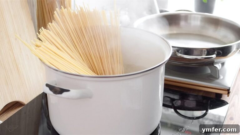 Creamy Vegan Pepper Pasta 19 Spaghetti boiling in a large pot, timed for al dente preparation.