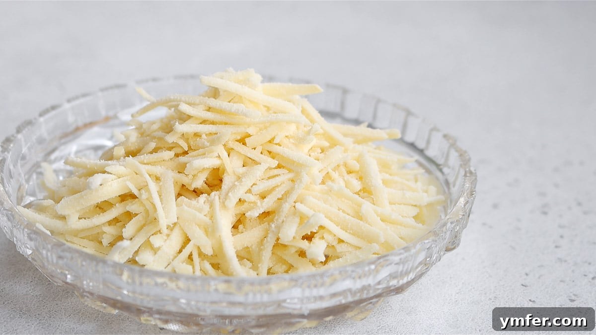 Creamy Vegan Pepper Pasta 4 A bowl filled with various types of vegan shredded cheese, ready for cooking.