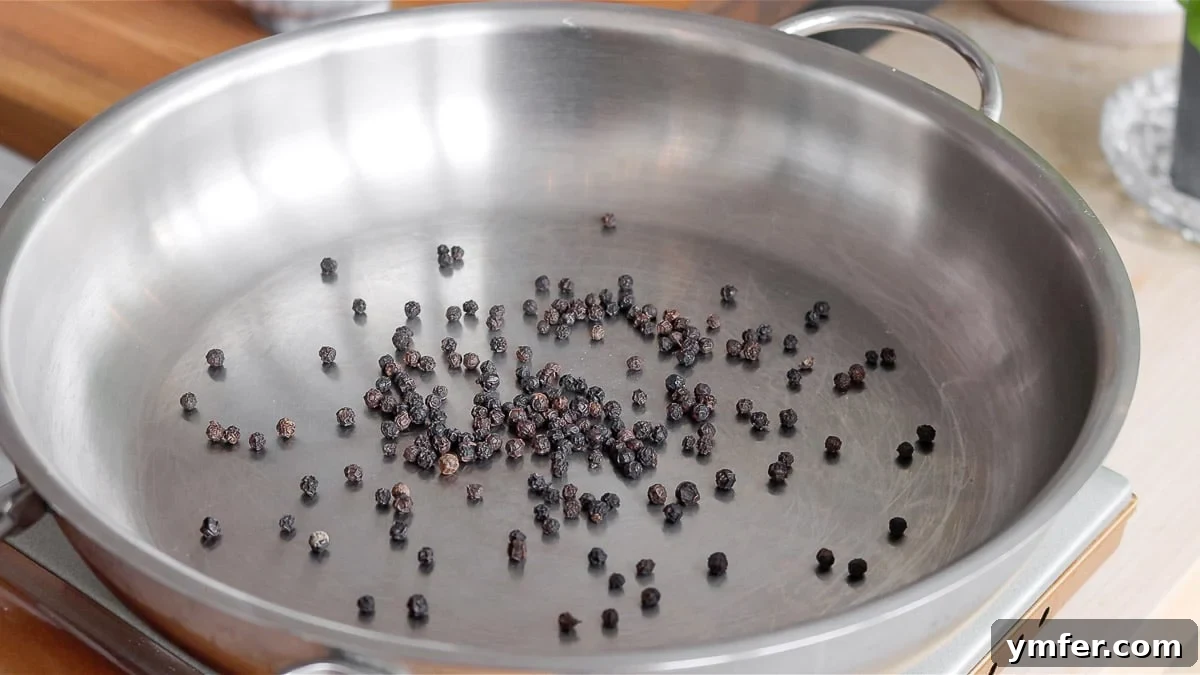 Creamy Vegan Pepper Pasta 6 Whole black peppercorns being toasted in a dry pan to enhance their aroma and flavor.