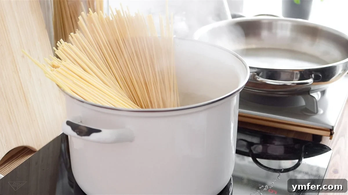 Creamy Vegan Pepper Pasta 8 Spaghetti cooking in a pot of boiling water, preparing for the sauce.