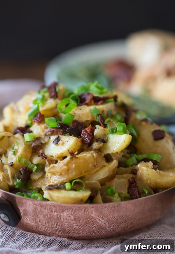 Savory Warm Potato Salad with Bacon and Fresh Herbs 4 A full spread featuring warm bacon herb potato salad alongside a roasted Perdue chicken, making for a complete and comforting meal, perfect for sharing.