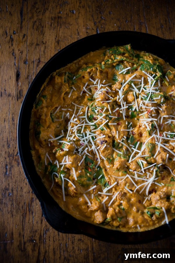 Rustic Spicy Pumpkin Sausage Sauce 2 A beautifully plated dish of spicy sausage pumpkin pasta sauce over pasta, garnished with fresh herbs, showcasing its rich texture and inviting fall colors.