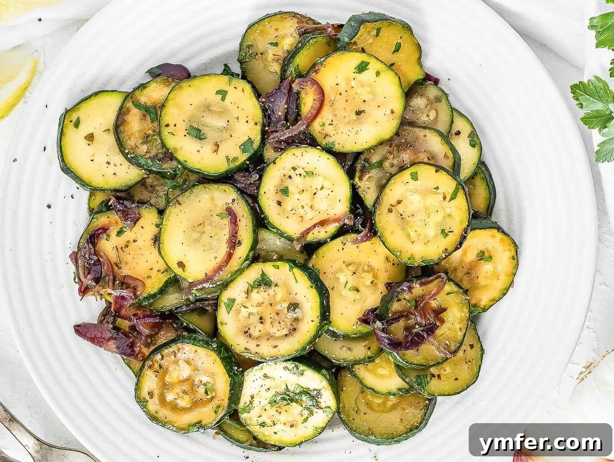 Flavorful Onion Dishes 12 Perfectly sautéed zucchini and onions on a white plate with a silver fork