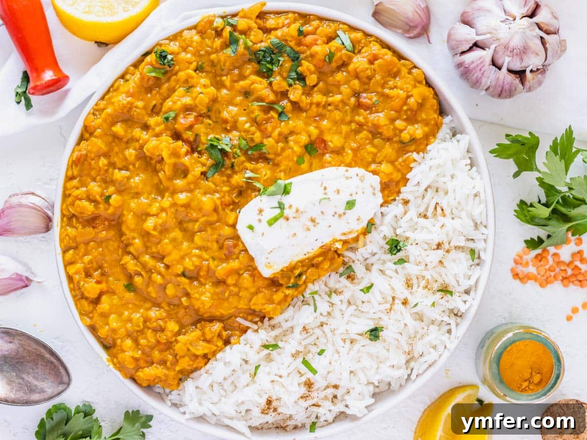 Flavorful Onion Dishes 13 Rich lentil curry recipe in a white bowl with a dollop of yogurt and fresh herbs