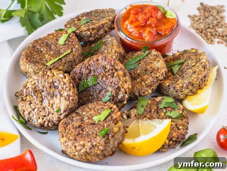 Spiced Lentil Delights 11 Delicious lentil patties served with a vibrant marinara sauce, garnished beautifully.