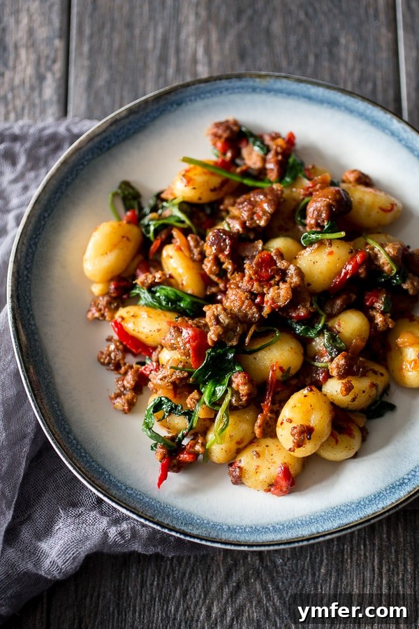 Smoky Chorizo Gnocchi with Roasted Red Pepper and Spinach 2 Flavorful chorizo, roasted red pepper, and spinach gnocchi served on a white plate, ready to eat.