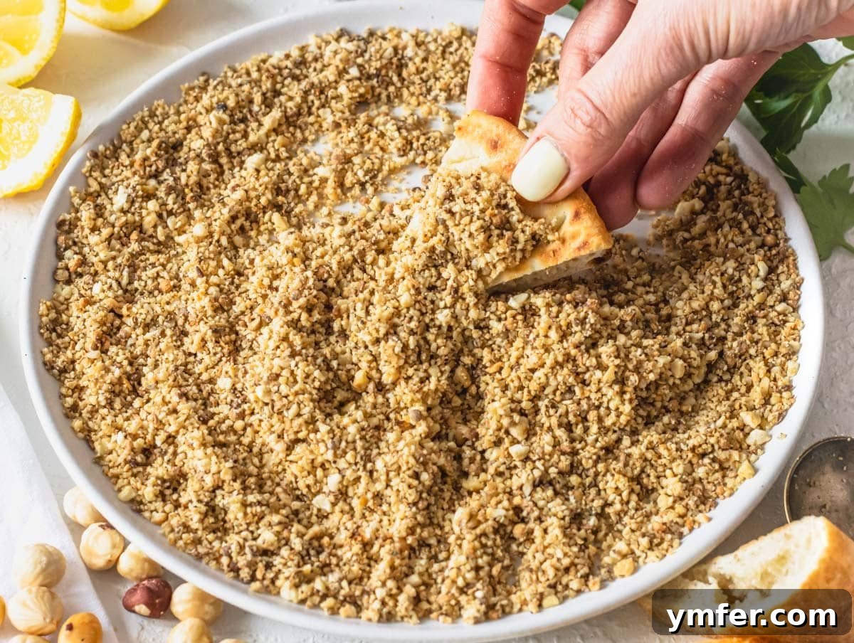 Dukkah dip with hand holding a pita