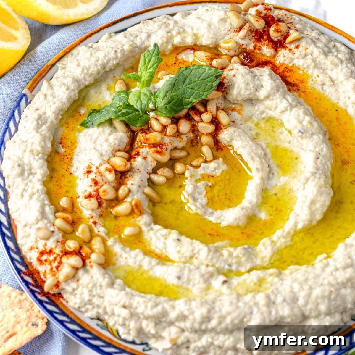 Mutabal on a plate with fresh mint and toasted pine nuts