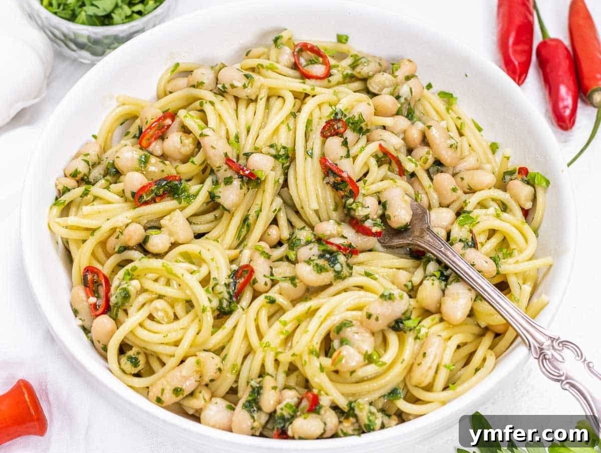 Protein-Packed Pasta Creations 12 Aglio e Olio pasta enriched with white beans, garnished with parsley and chili flakes.