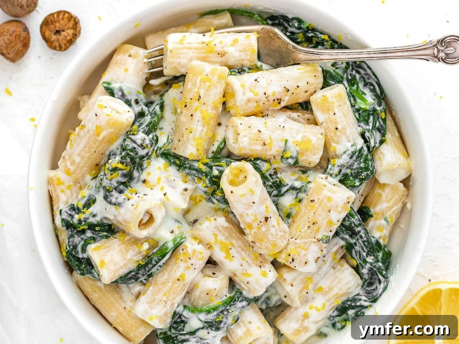 Protein-Packed Pasta Creations 13 Lemon Ricotta Pasta in a bowl with a fork, showing its creamy texture.
