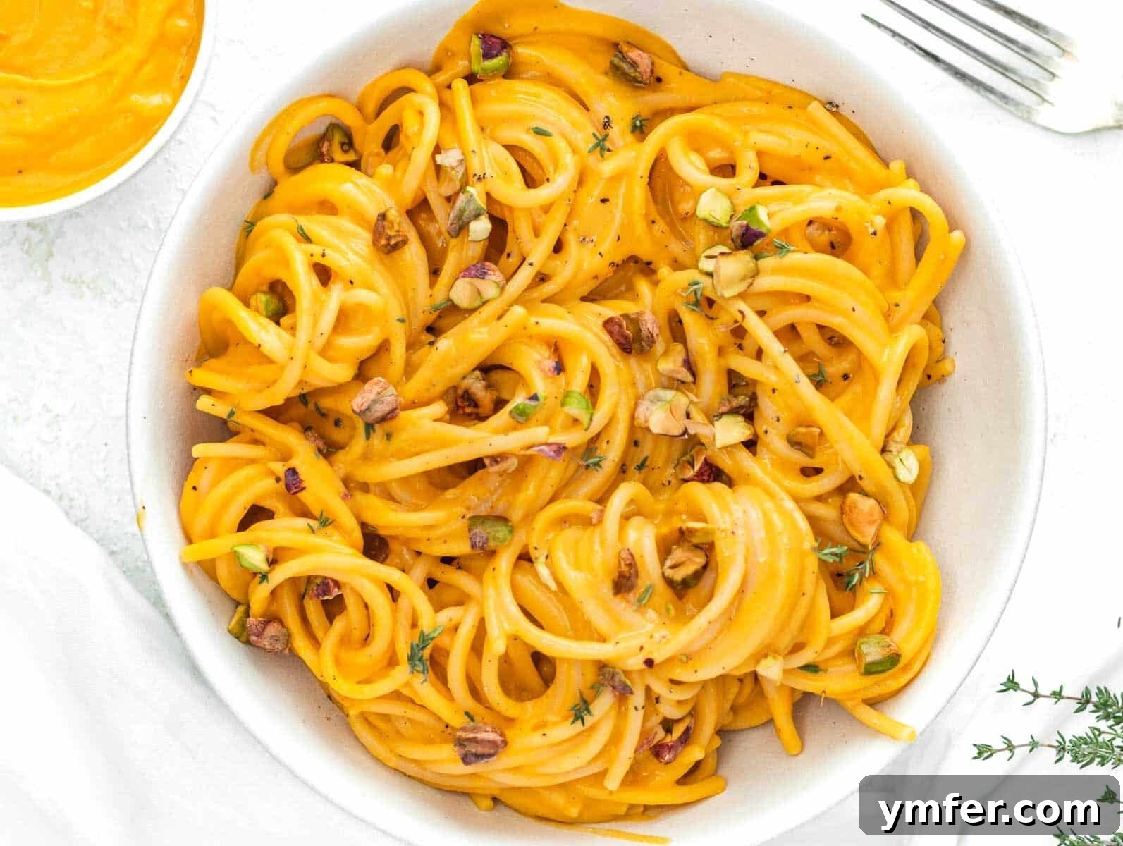 Protein-Packed Pasta Creations 19 Kabocha squash pasta with a fork, showcasing its rich, creamy sauce.