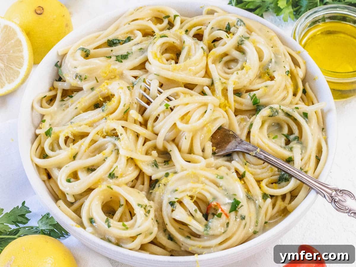 Protein-Packed Pasta Creations 25 Creamy Lemon Pasta served in a bowl with a fork, garnished with fresh herbs.