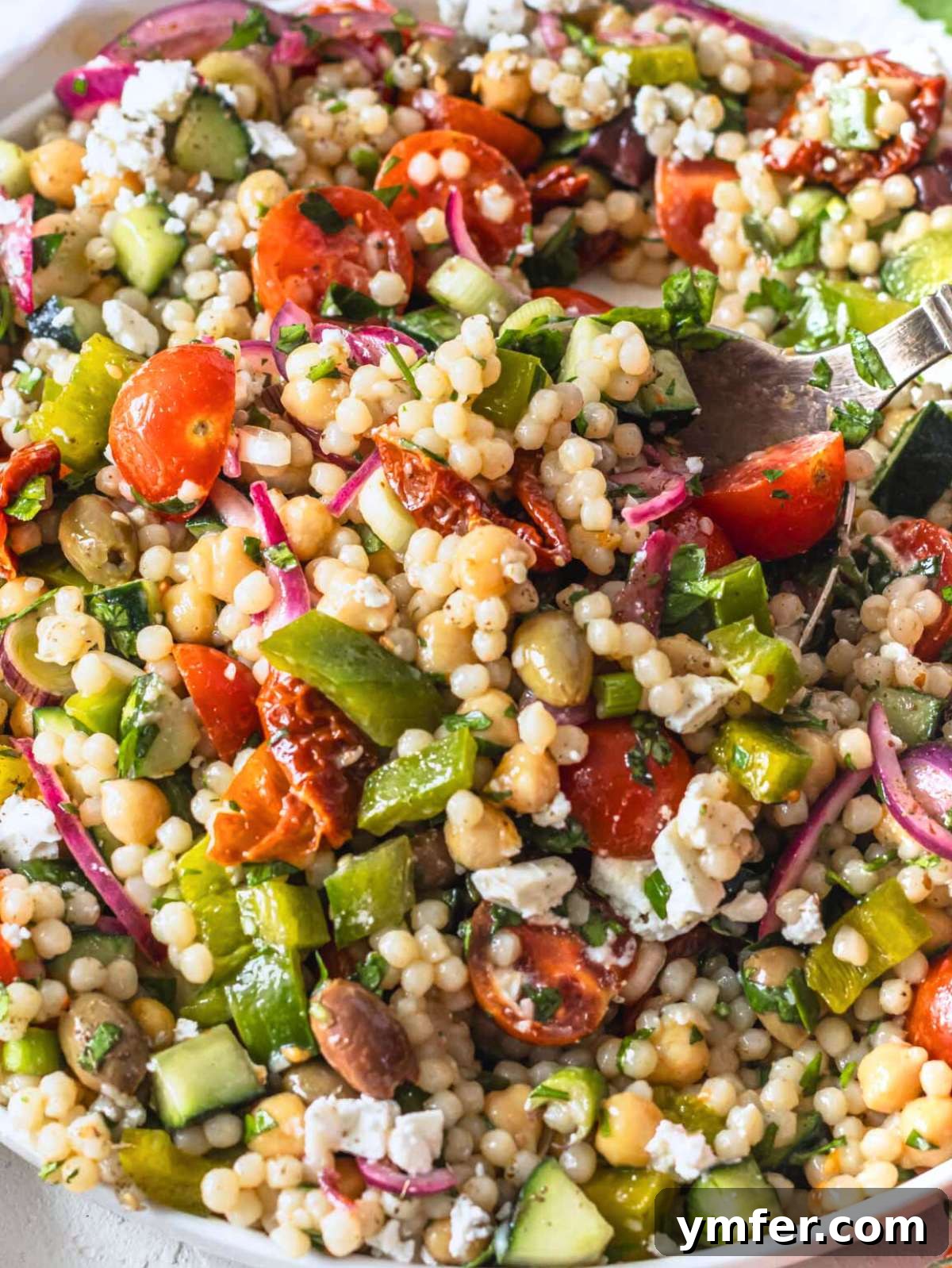 Vibrant Mediterranean Pearl Couscous Salad with fresh vegetables and feta.