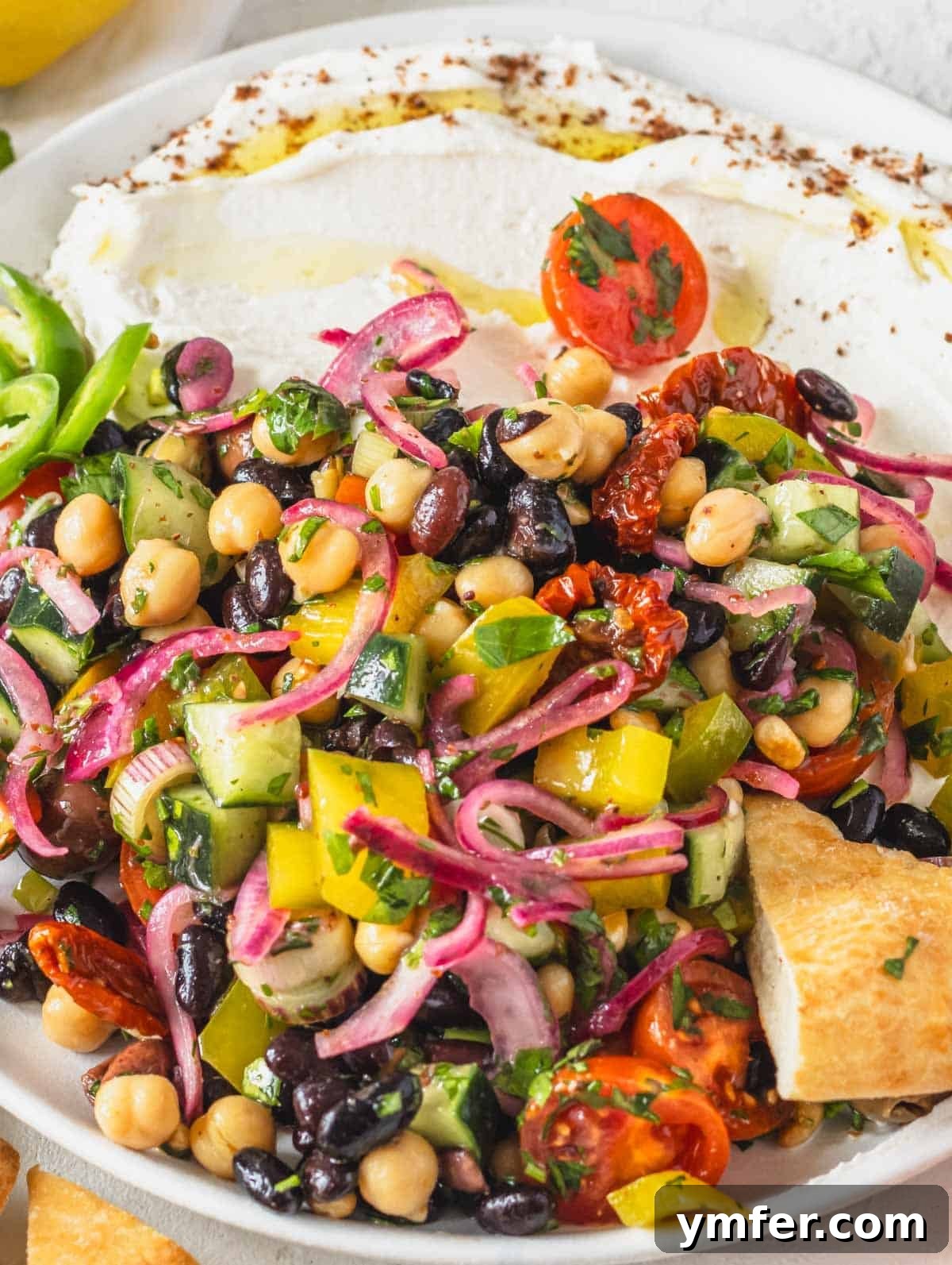 Grecian Summer Salad 3 Assorted chopped vegetables, legumes, and herbs for a Mediterranean salad prepared in a large mixing bowl.