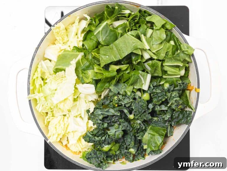 leafy greens added to the simmering soup base