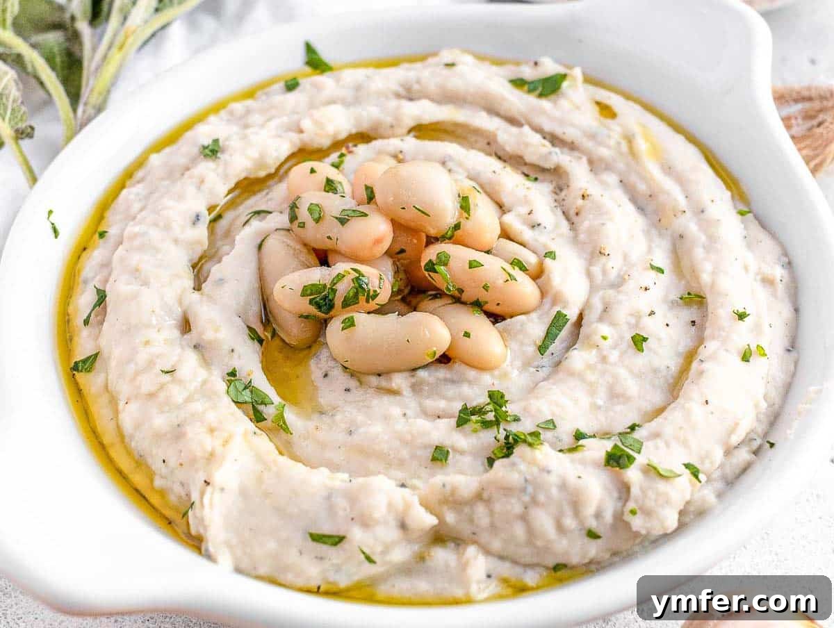 15 Quick and Easy Cannellini Bean Dishes 4 Creamy white bean dip in a white bowl, garnished and ready to serve