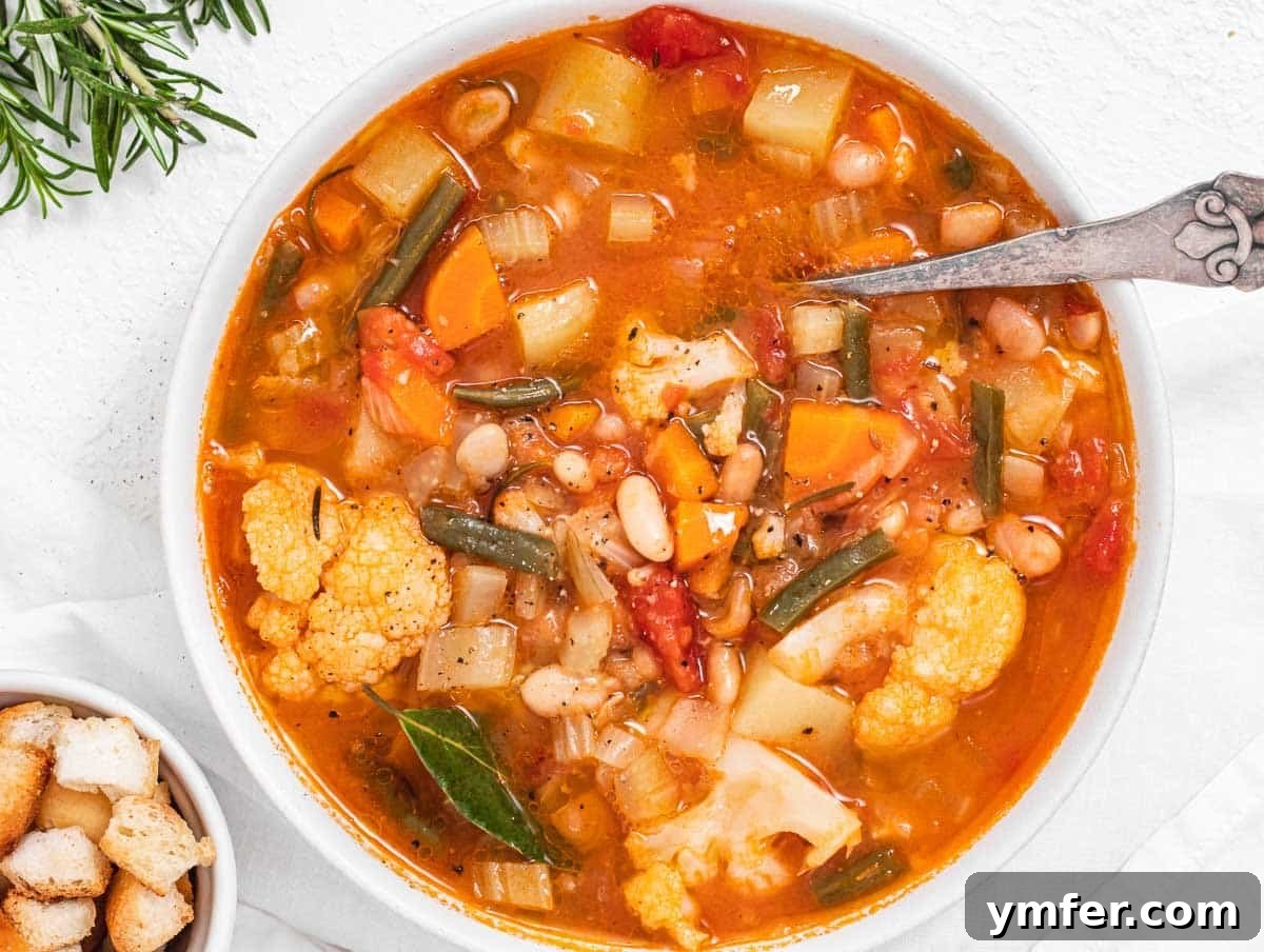 15 Quick and Easy Cannellini Bean Dishes 5 Nourishing vegetable soup with a silver spoon, showcasing a vibrant mix of ingredients
