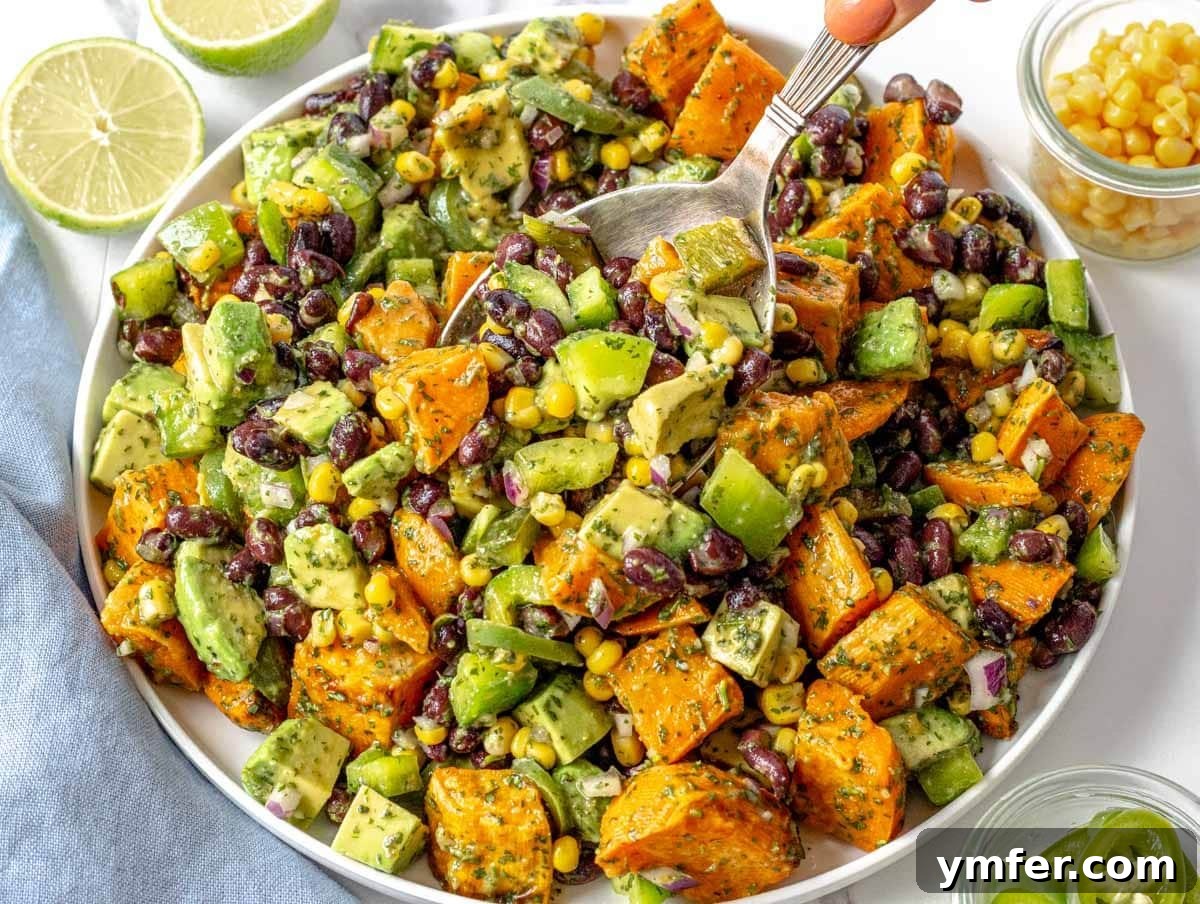Fifteen Fantastic Black Bean Feasts 4 black bean salad with avocado, corn, and a hand holding a spoon
