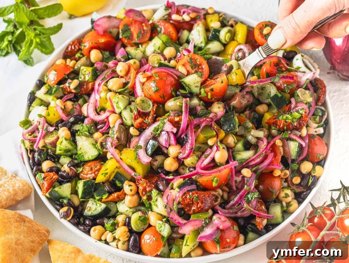 Fifteen Fantastic Black Bean Feasts 6 Mediterranean salad with sumac onions and hand holding a silver spoon
