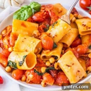 paccheri pasta with cherry tomatoes and fresh basil on a white plate