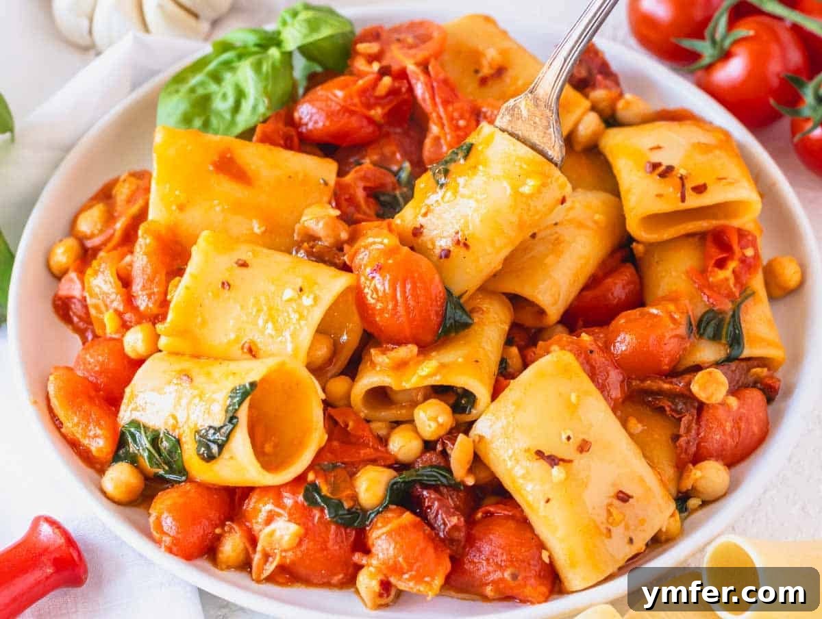 Paccheri: Italy's Grand Tubes 7 paccheri pasta with a fork on a white plate