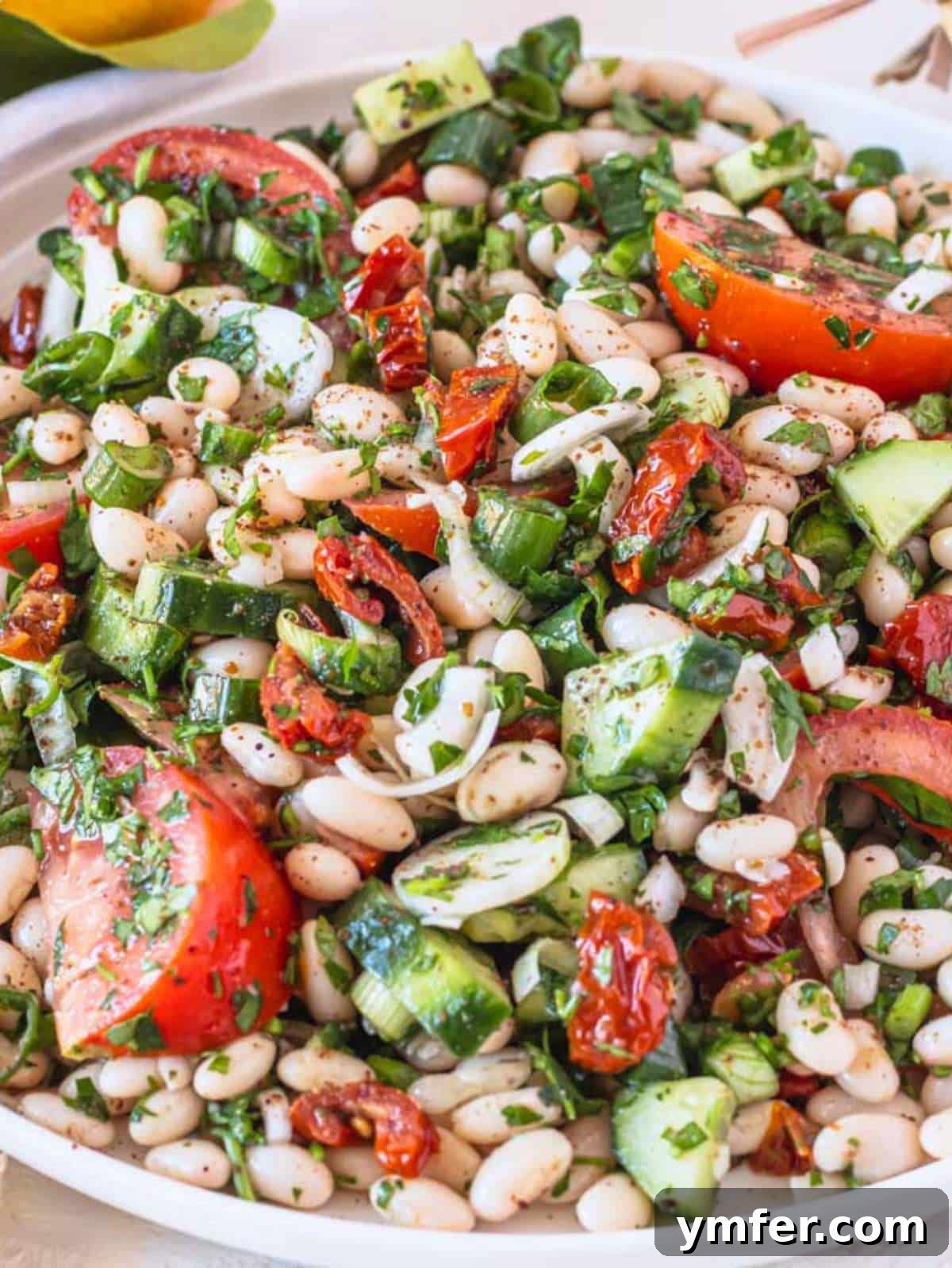 Mediterranean White Bean Salad 2 A delicious bowl of Mediterranean white bean salad, garnished with fresh herbs.
