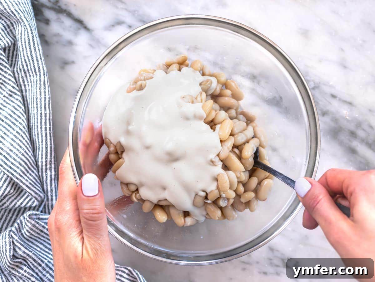 Piyaz Zesty Turkish White Bean Salad 13 Cooked cannellini beans drenched in creamy tahini sauce in a mixing bowl