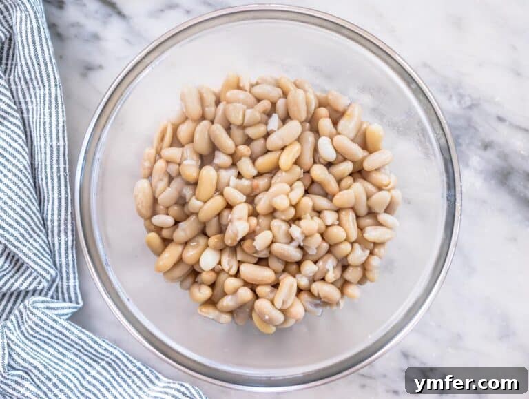 Cooked white beans in a glass bowl, ready for the next step