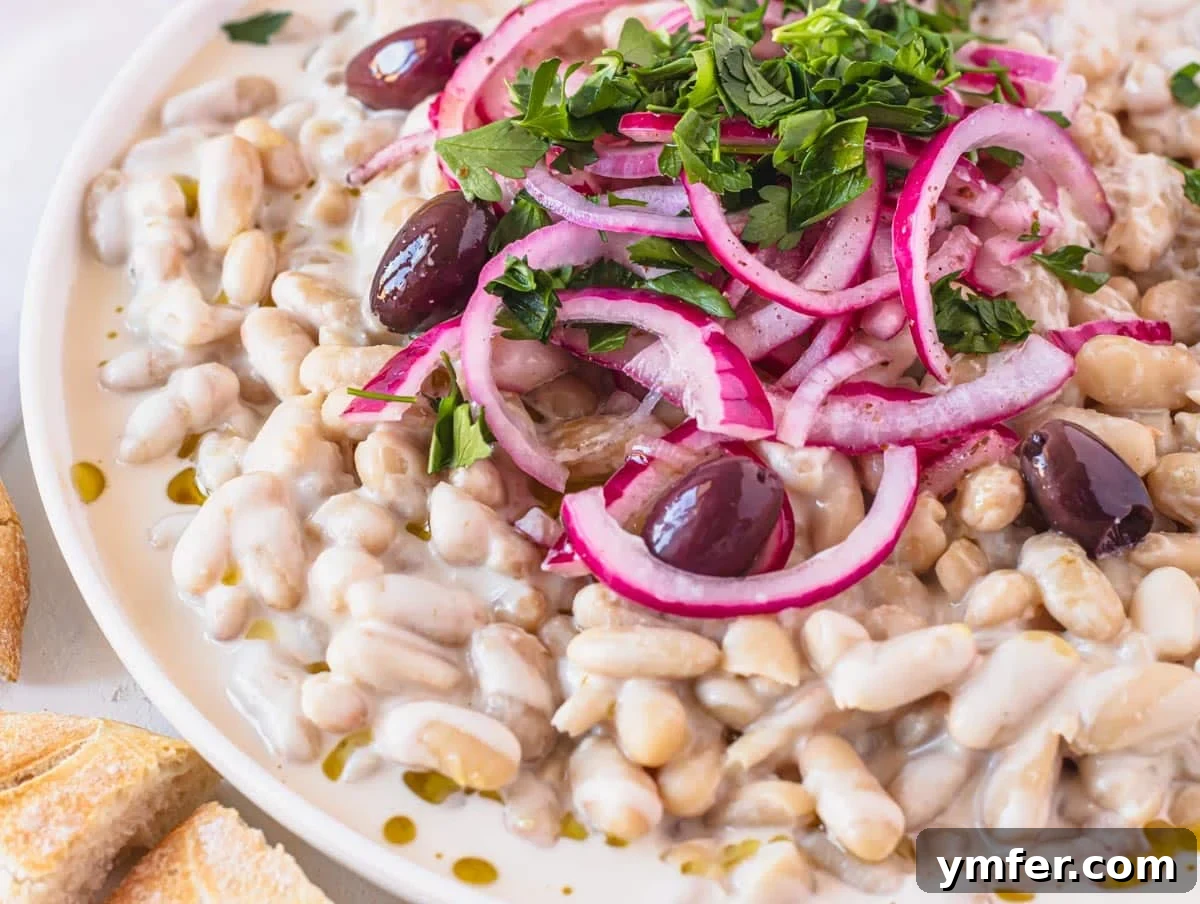 Piyaz Zesty Turkish White Bean Salad 8 Close-up of Piyaz with olives and beautifully marinated red onions on a white plate, ready to be served