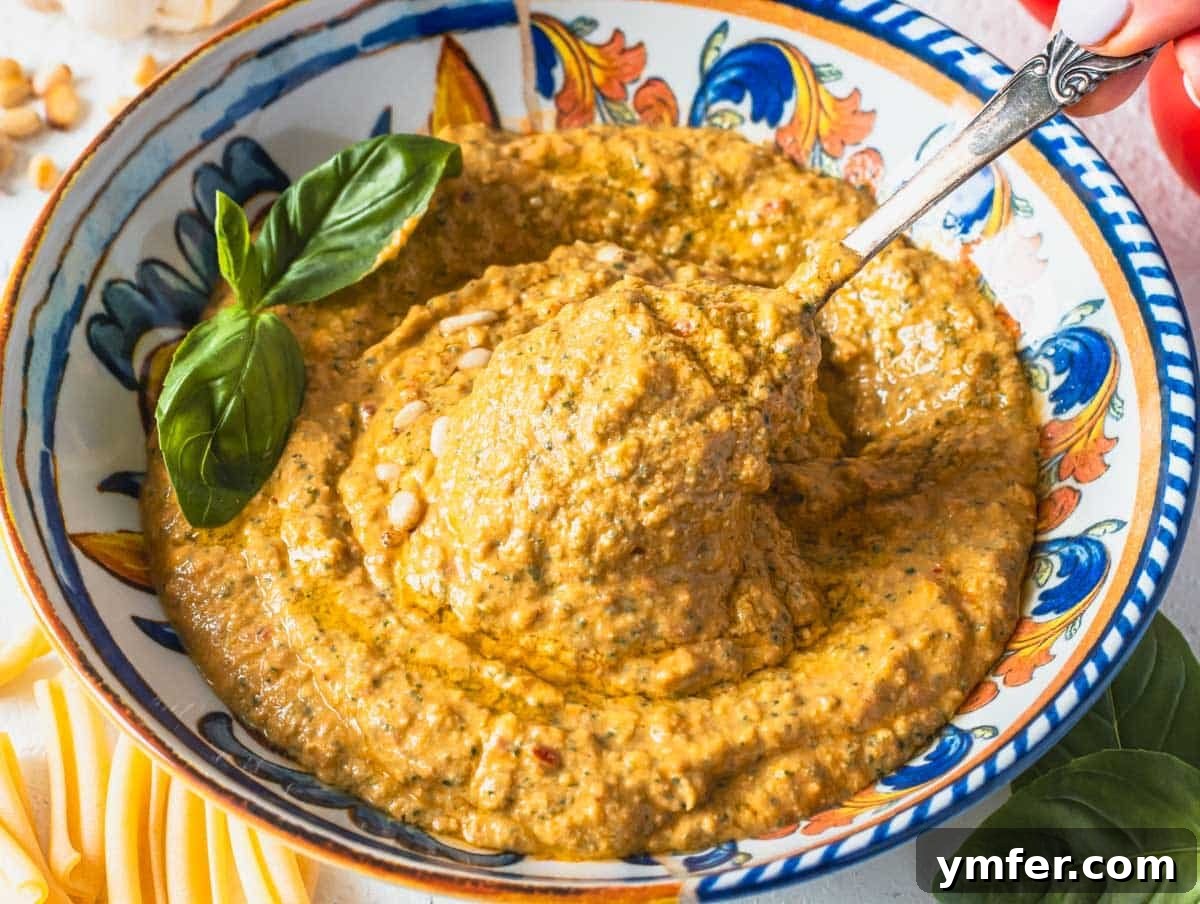Sicilian Red Pesto 3 red tomato pesto in a bowl with a silver spoon