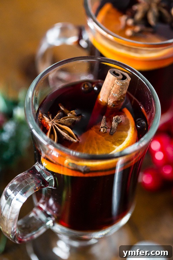 Fireside Simmered Spiced Wine 3 Slow Cooker Spiced Mulled Wine in a glass with an orange slice.