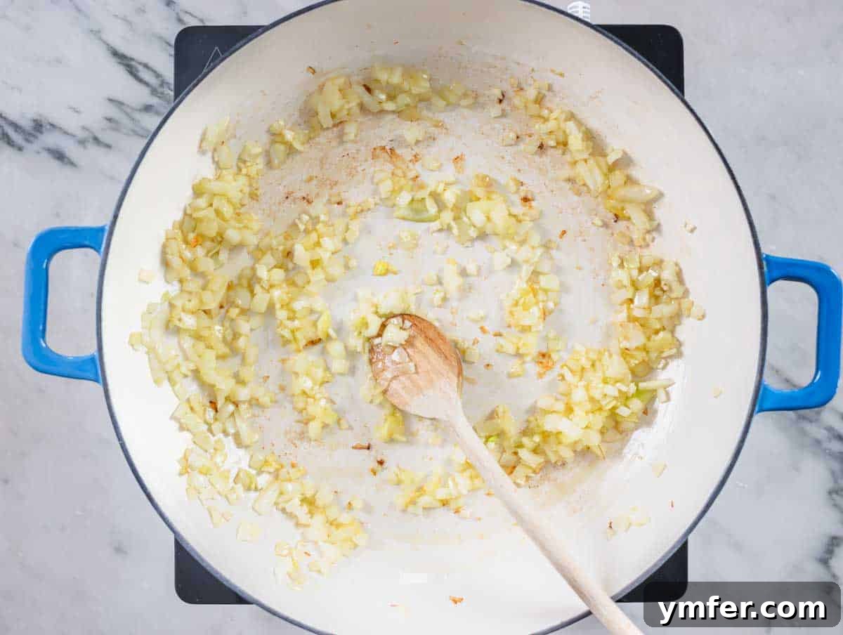 Sardinia's Toasted Pearl Pasta 9 Onions sautéing in a blue skillet, beginning to soften.